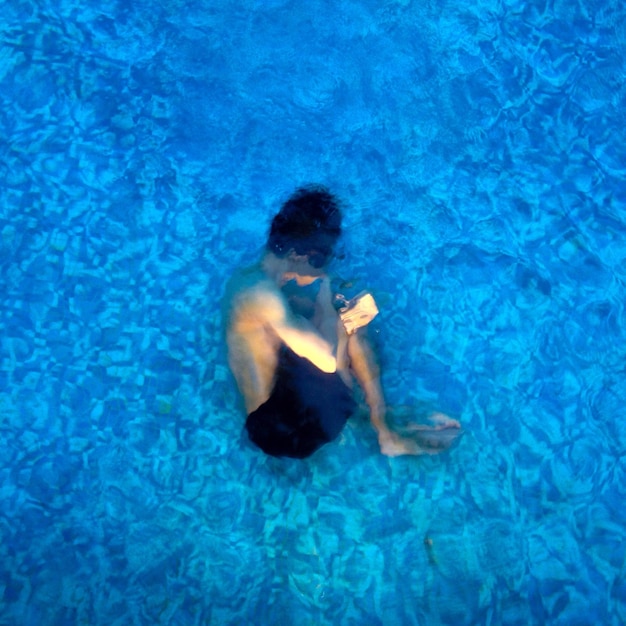 Un homme nageant dans une piscine.