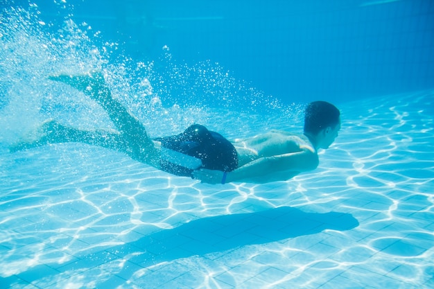 Homme nageant sous l'eau dans une piscine