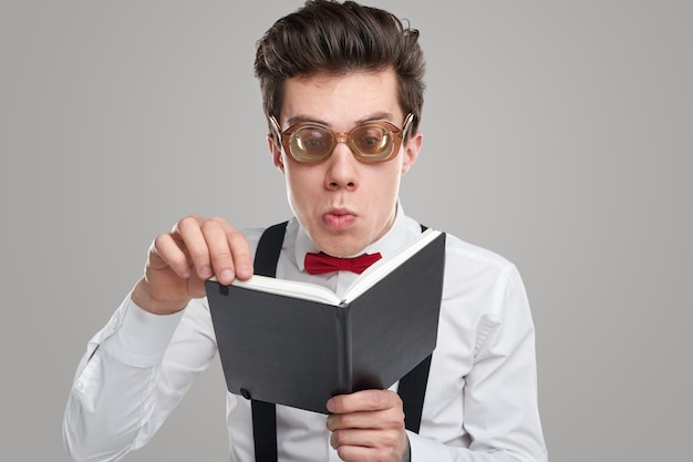 Homme nerd à lunettes, livre de lecture en studio