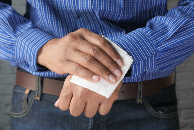 L'homme nettoie les mains avec une lingette humide antiseptique.