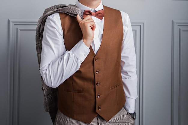 Homme en noeud papillon et gilet dans la chambre