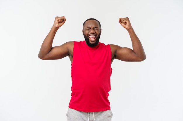 Homme noir africain de fitness jeune dans les vêtements de sport acclamant insouciant et excité, concept de victoire.