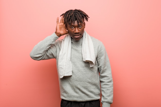 Homme noir africain de fitness jeunes essayant d'écouter un commérage.