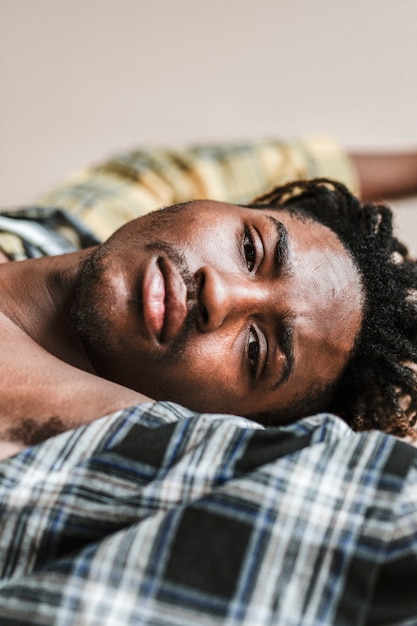 Homme noir allongé sur un t-shirt à carreaux