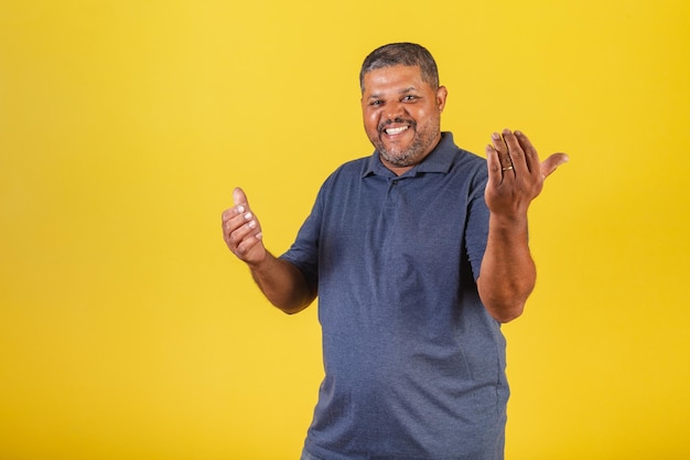 Homme noir brésilien adulte souriant invitant avec ses mains appelant venir