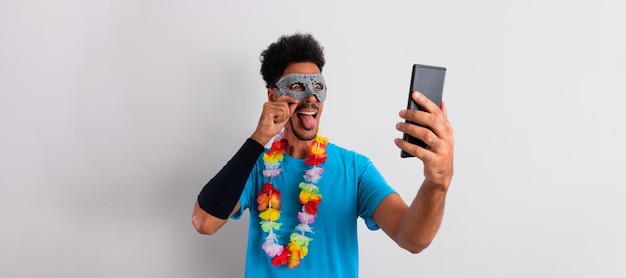 Homme noir brésilien avec costume de carnaval tenant un mobile isolé sur blanc