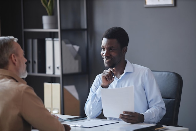 Photo homme noir écoutant un candidat senior lors d'un entretien d'embauche