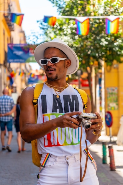 Un homme noir gay à la fête de la fierté en regardant les photos sur le drapeau LGBT de l'appareil photo