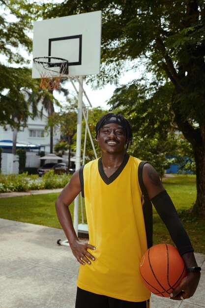 Un homme noir joue au streetball.