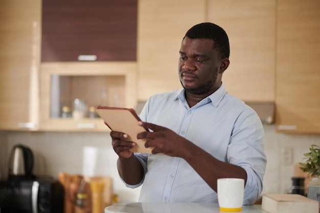 Homme noir lisant un article sur une tablette