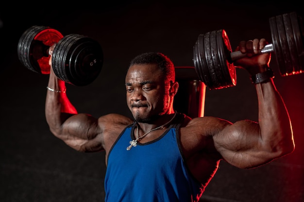 Homme noir musclé fort entraînant son corps Beau bodybuilder athlétique dans la salle de gym