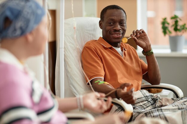 Photo un homme noir souriant qui parle à un autre patient.