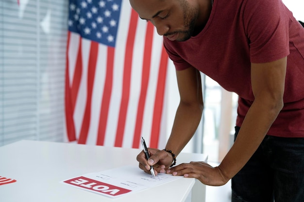 Un homme noir vote au bureau de vote.