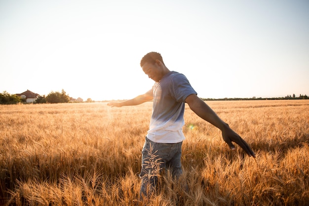 Homme non spécifié avec les mains en l'air en regardant le coucher du soleil