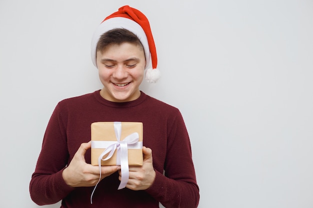 Homme offrant ou montrant un cadeau pour quelqu'un. Heureux jeune hipster avec un cadeau en mains.