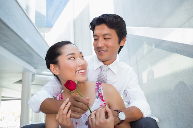 Homme offrant une rose rouge à sa petite amie