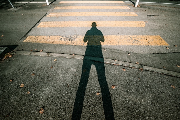 Homme avec une ombre sur la route