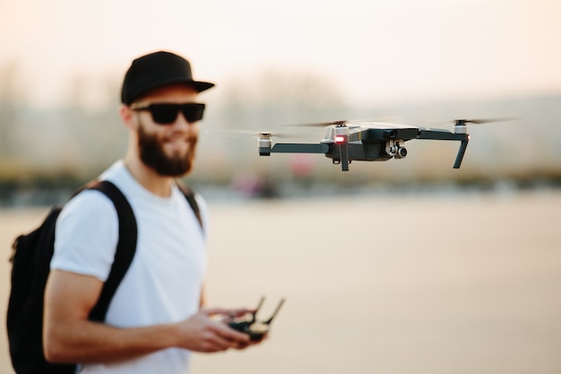 Homme opérant le drone par télécommande et s'amusant