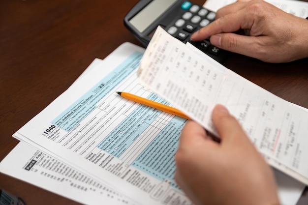 Un homme organisant le formulaire 1040 de déclaration d'impôt sur le revenu individuel et les reçus