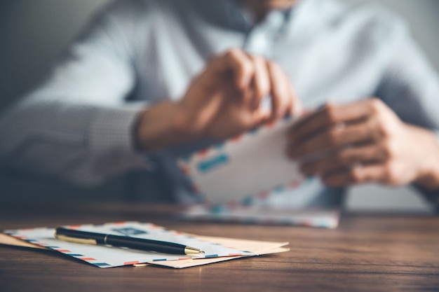 Homme ouvrant et lisant des lettres sur 24