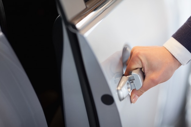 Homme ouvrant une porte de voiture