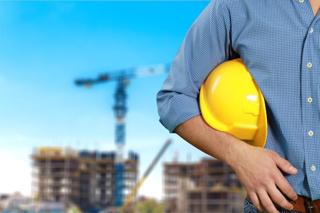 Homme ouvrier avec casque sur fond de construction