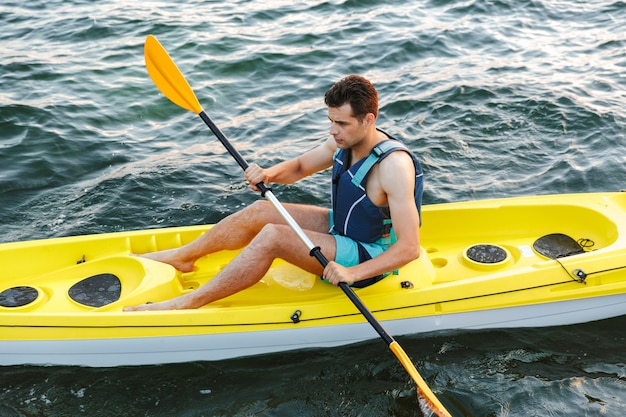 Homme pagayant un kayak