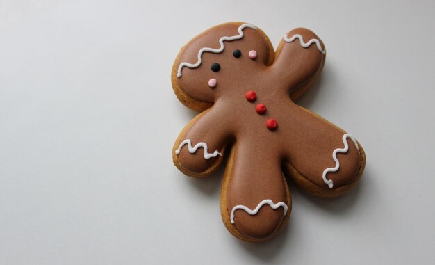 Homme de pain d'épice décoratif avec du glaçage au chocolat sur une surface blanche