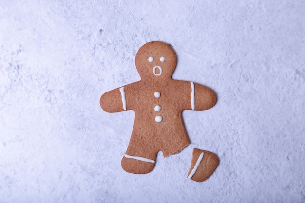 Homme de pain d'épice avec une jambe cassée (sans jambe) et avec un visage surpris. Biscuits traditionnels du Nouvel An et de Noël faits maison. Mise au point sélective, gros plan.