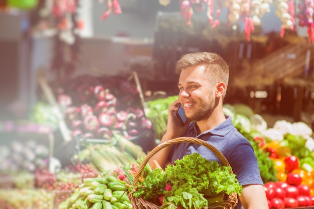 Un homme avec un panier au marché agricole