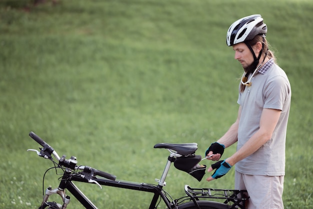 Homme avec panne de vélo répare son vélo dans une rue