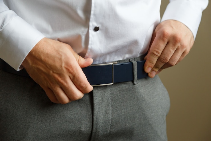 Photo un homme en pantalon bleu et une chemise blanche boutonnée une ceinture de pantalon en cuir marron