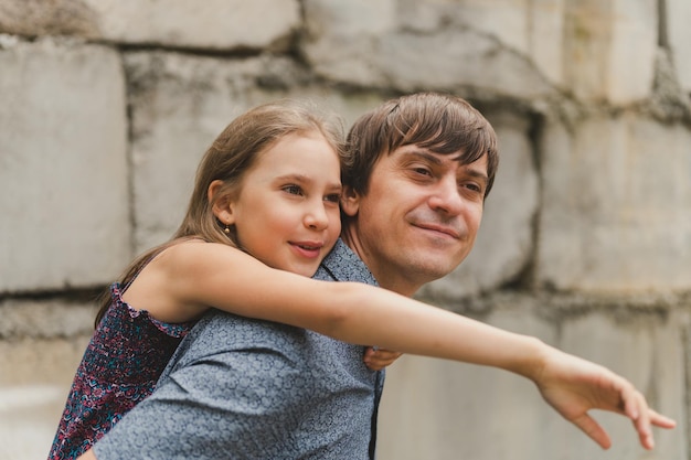 Homme papa ayant du temps de qualité avec leur enfant fille fille de neuf ans sur le dos heureux père jouant avec l'enfant dans la vraie vie authentiques moments de paternité au jour le jour amour paternel soins et affection