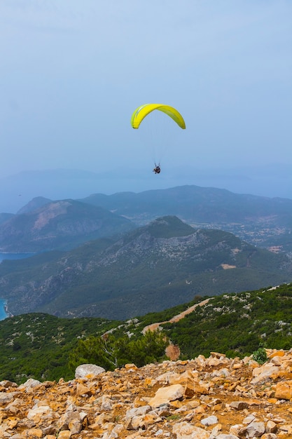 Un homme en parachute vole au-dessus des montagnes