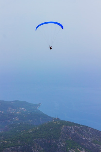 Un homme en parachute vole au-dessus des montagnes