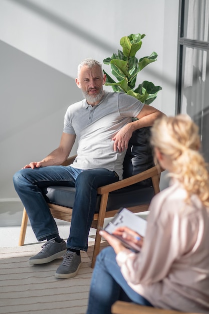 Homme parlant à une femme blonde et semblant impliqué