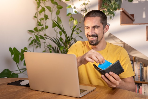 Homme payant avec carte de crédit sur ordinateur portable achats en ligne au bureau à domicile