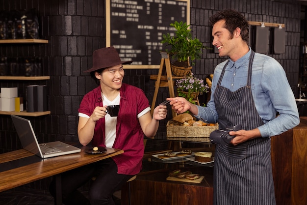 Homme payant son café avec carte de crédit