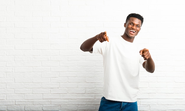 Un homme à la peau foncée vous montre du doigt en souriant