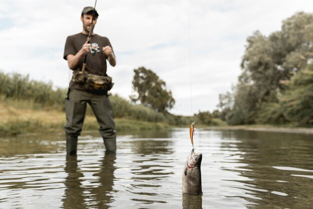 Photo homme pêchant à la rivière