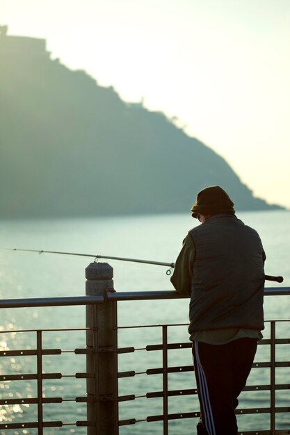 Photo homme pêcheur face à la mer