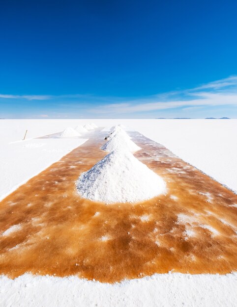 L'homme pelle les banques de sault dans le grand soleil salar de uyuni