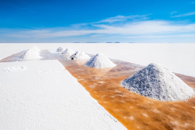 Un homme pelle des berges de sault dans le Salar de Uyuni