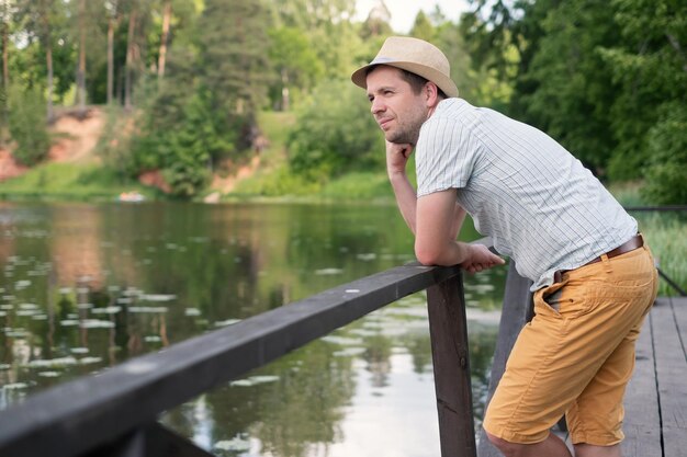 Homme pensif pensant se reposer en plein air près du lac