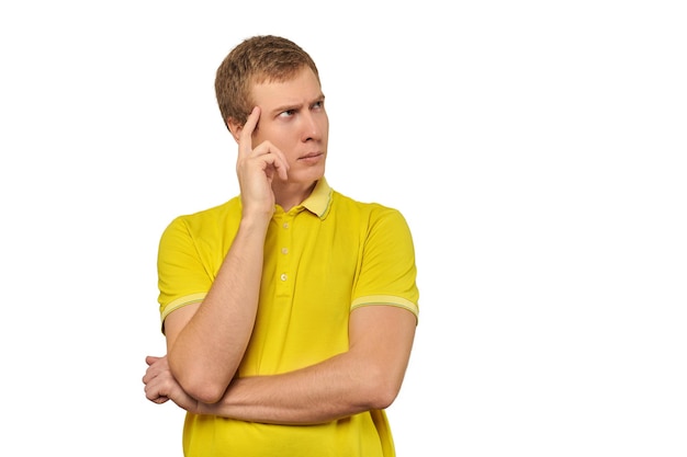 Homme pensif en T-shirt jaune regardant à droite réflexion philosophique sur fond blanc