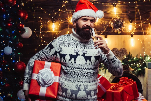 Homme père Noël. Concept de Noël du nouvel an. Styling homme avec une longue barbe posant sur le fond en bois. Père Noël à la maison