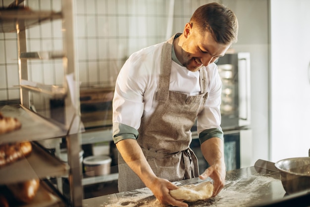 Photo l'homme pétrit la pâte pour le pain