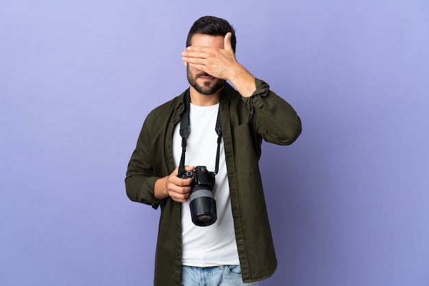 Homme photographe sur mur violet isolé couvrant les yeux par les mains. Je ne veux pas voir quelque chose