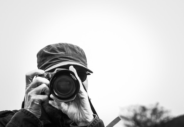 Un homme photographiant avec un appareil photo contre un ciel dégagé