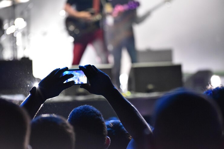 Photo un homme photographie un concert de musique.